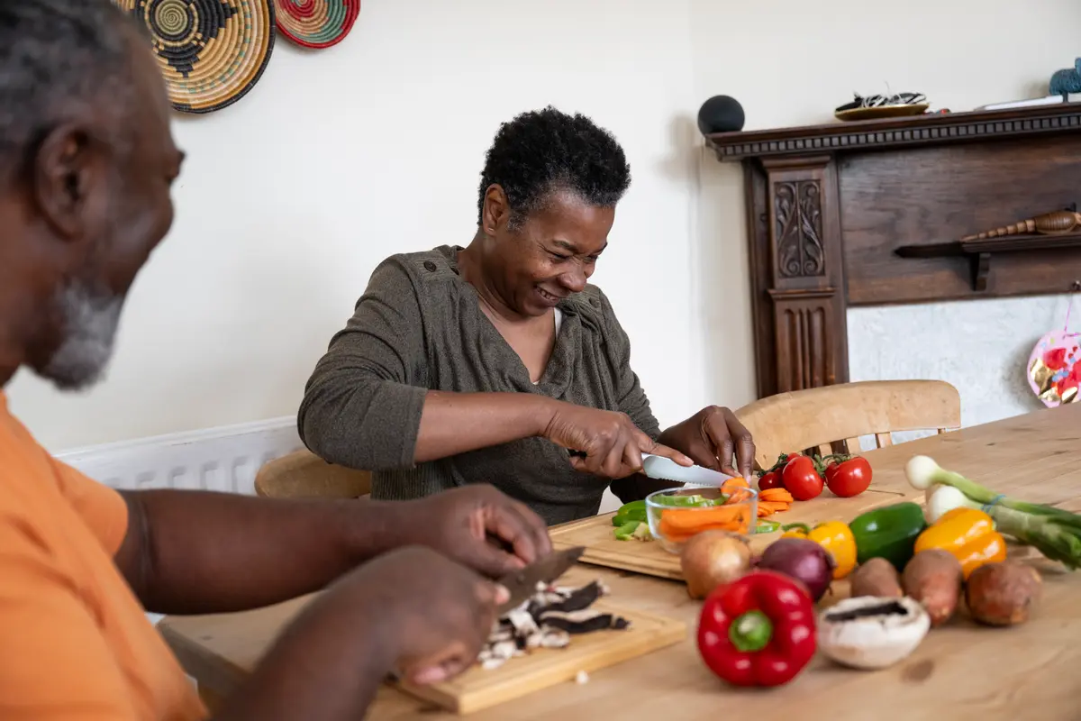 Woman cutting vegetables smiling.