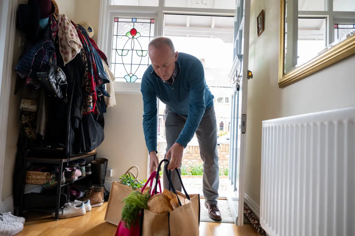 Man putting down groceries.
