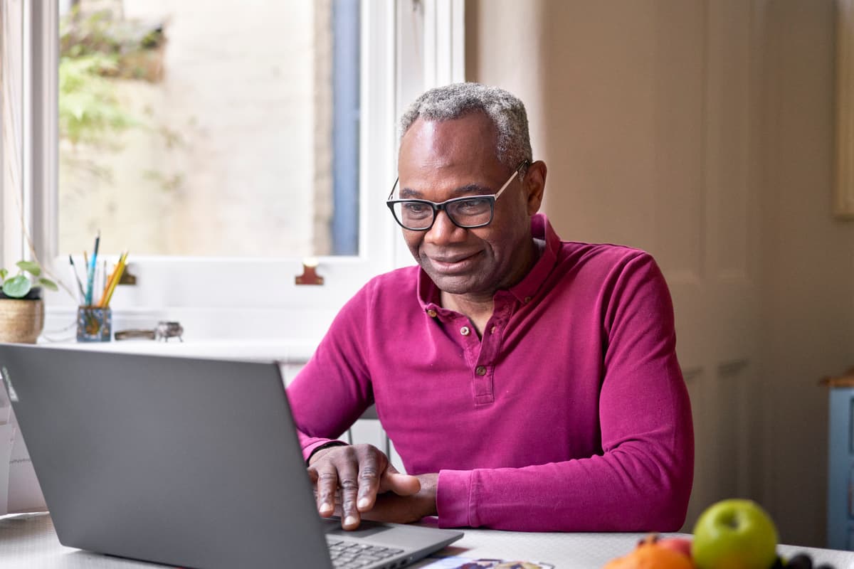 A photo of a man looking at his laptop.