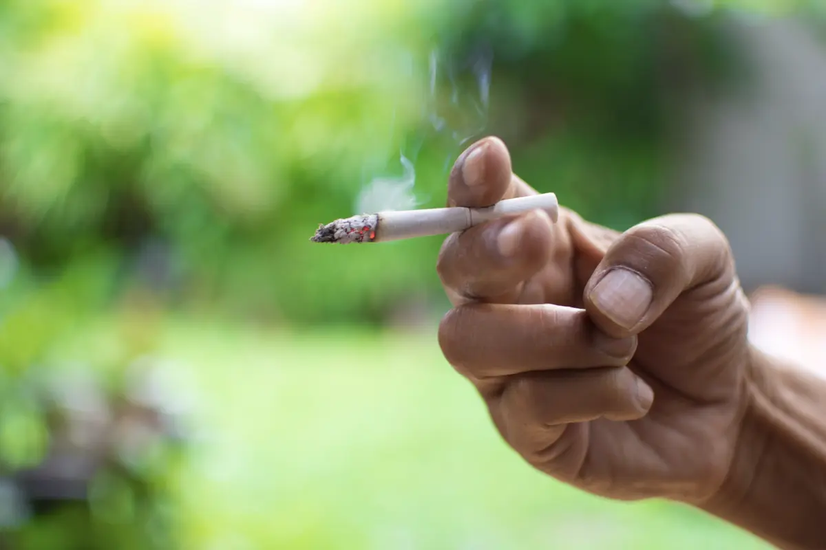 Smoking a cigarette.