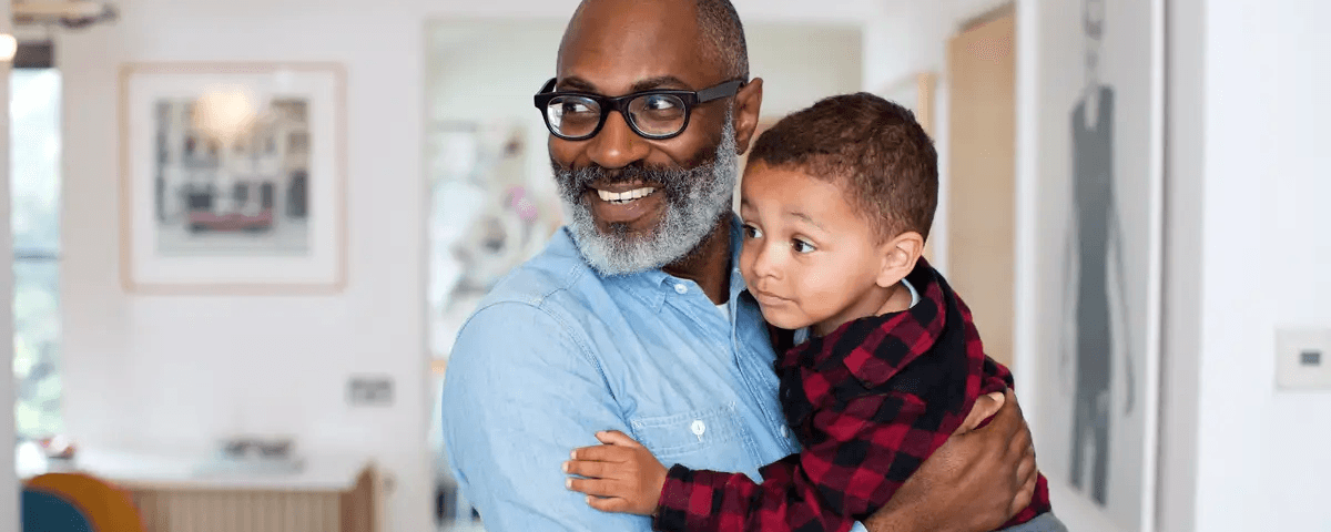 Grandson in grandfathers arms.