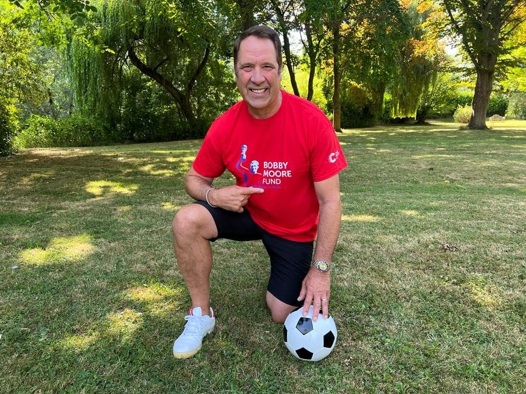 Image of David Seaman with a bobby moore top and a football in one hand.