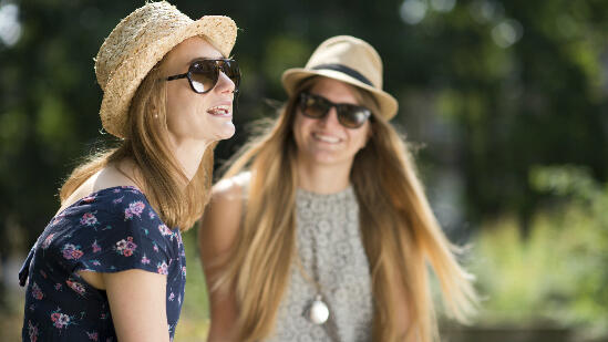 Friends wear straw hats in the sun