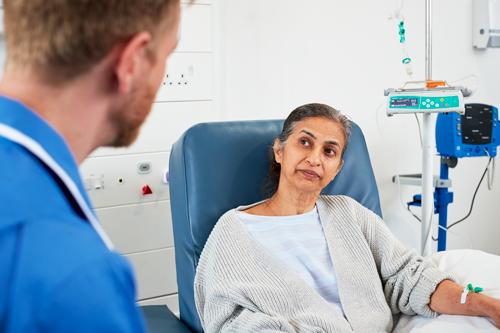 Cancer patient receiving treatment and assistance from nurses