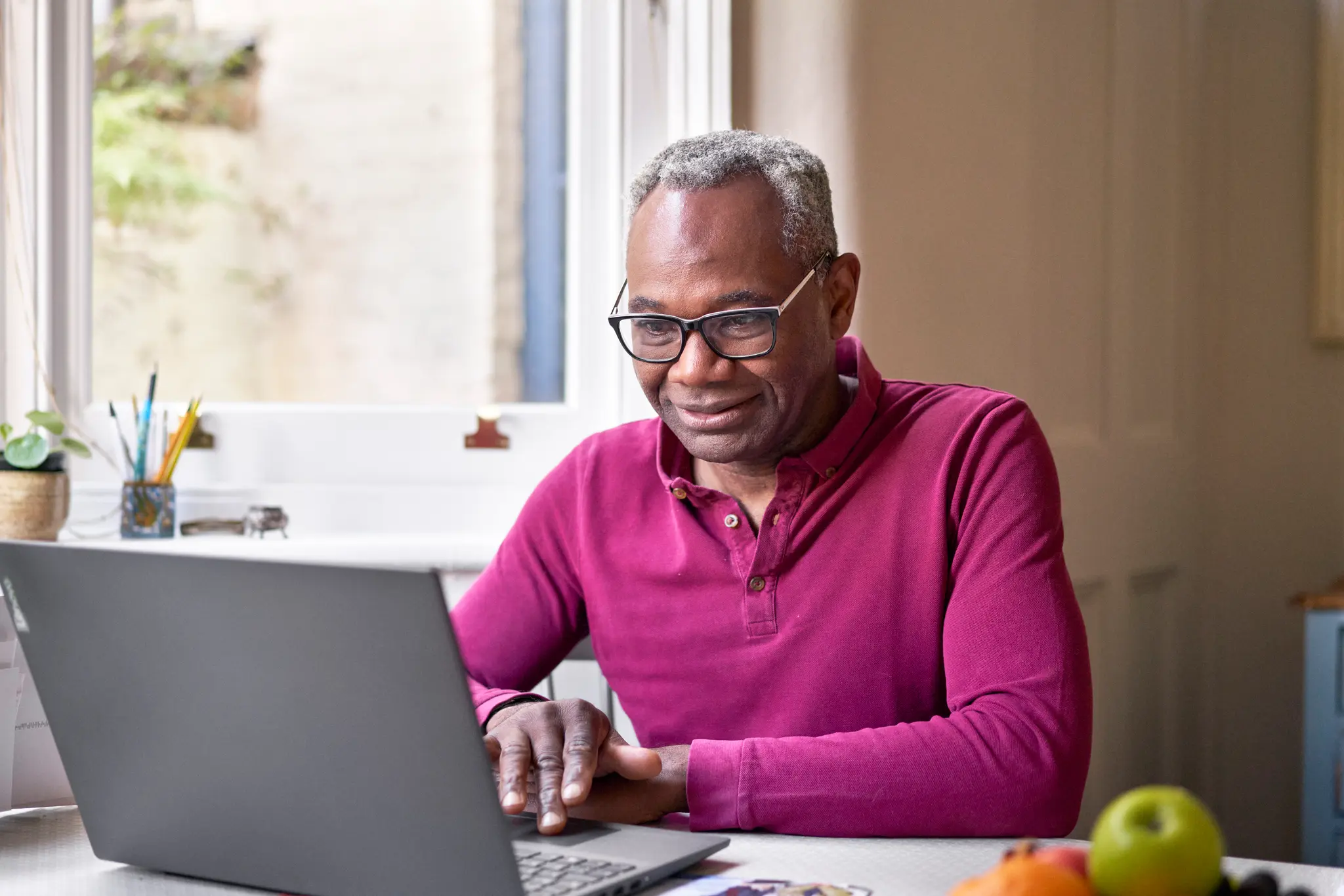 Photo of a man looking at a laptop.