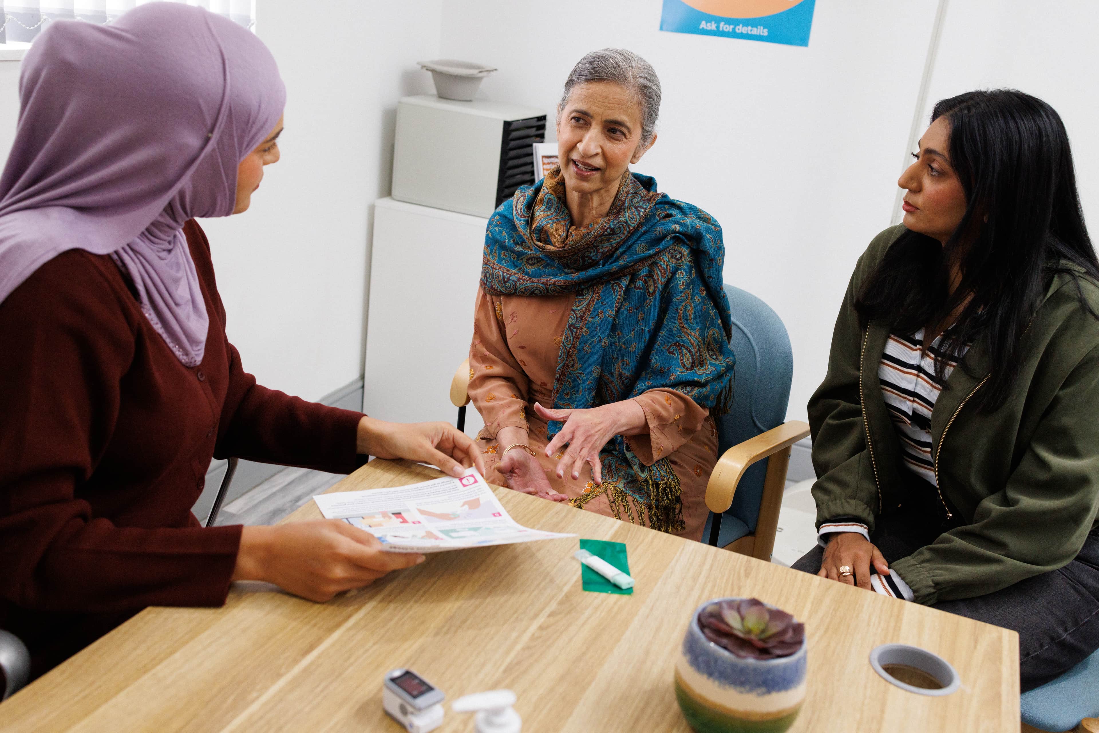 Doctor at the GP surgery talking to the patient and her carer.