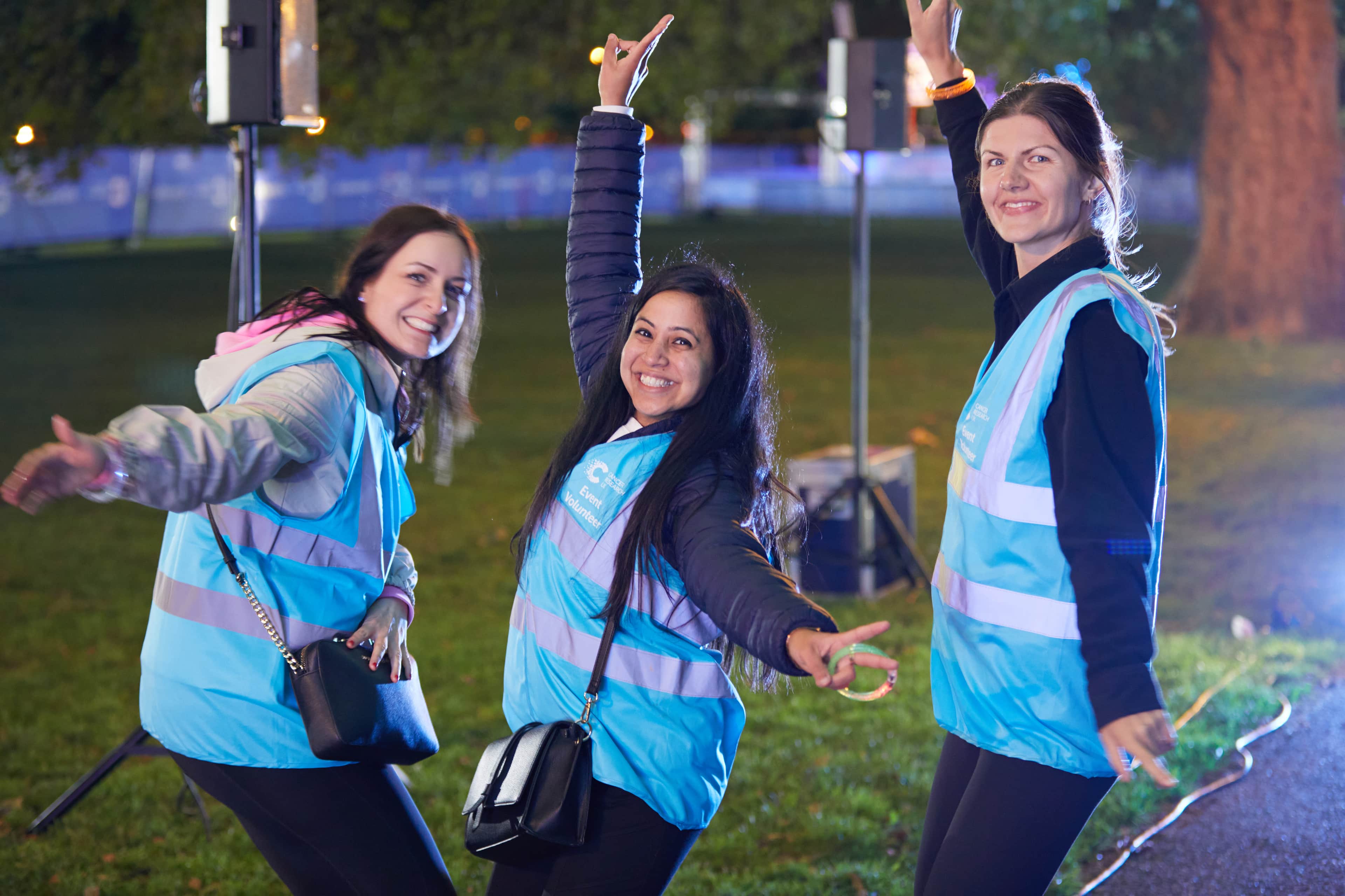 Three volunteers posing in high vis jackets at Shine Night Walk.