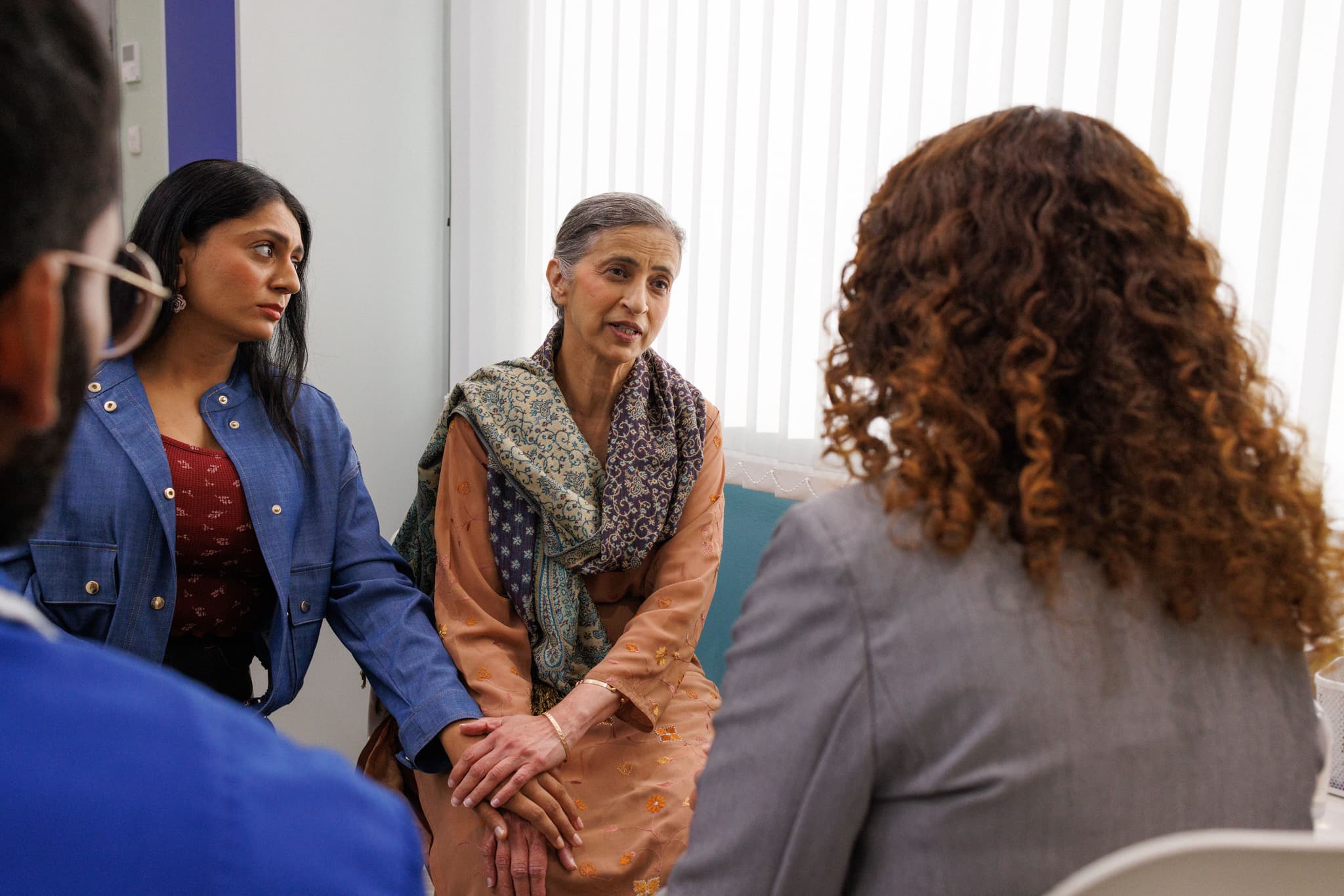 Photograph showing doctors speaking to the patient and her carer.