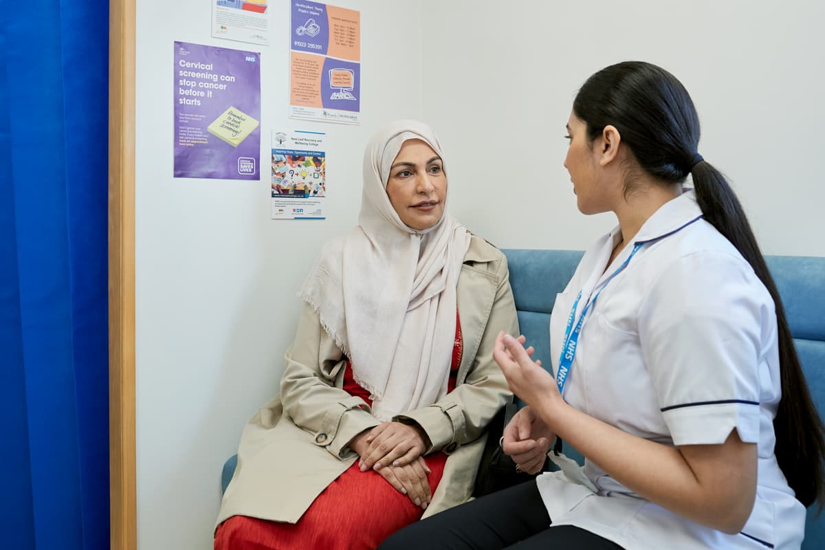 This photo shows a patient and mamographer in the waiting room of a mobile breast screening unit.