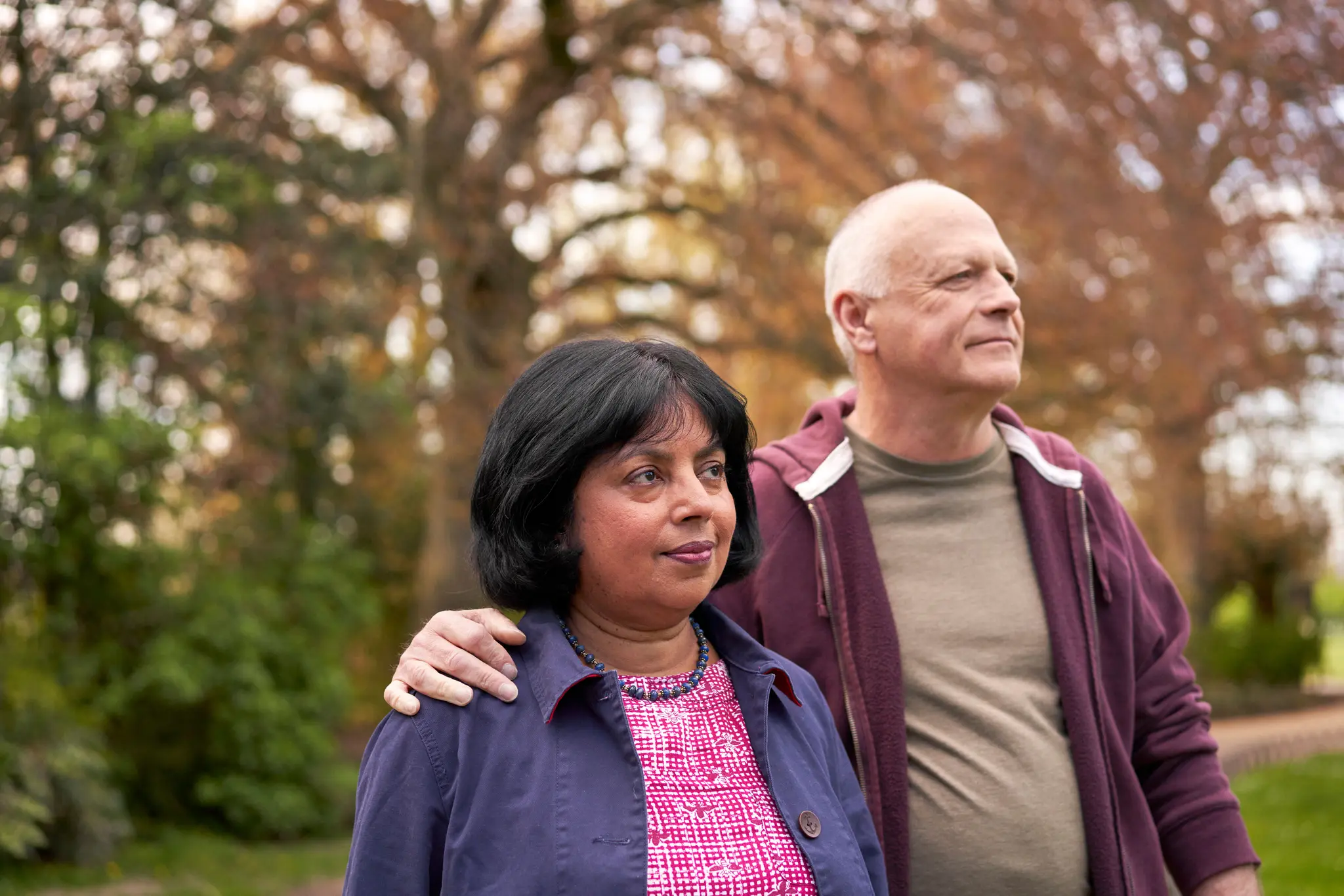 Photograph showing a couple walking side by side in a park.