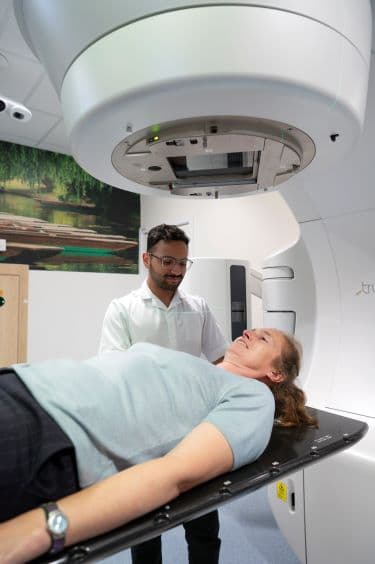 Photo of a radiographer and a patient about to have radiotherapy.