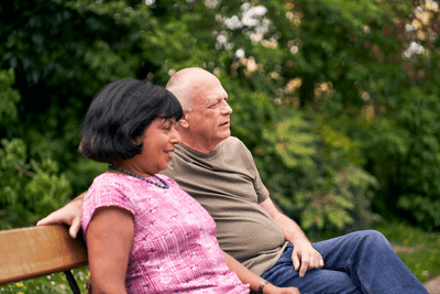 Photograph showing a couple sitting on a bench.