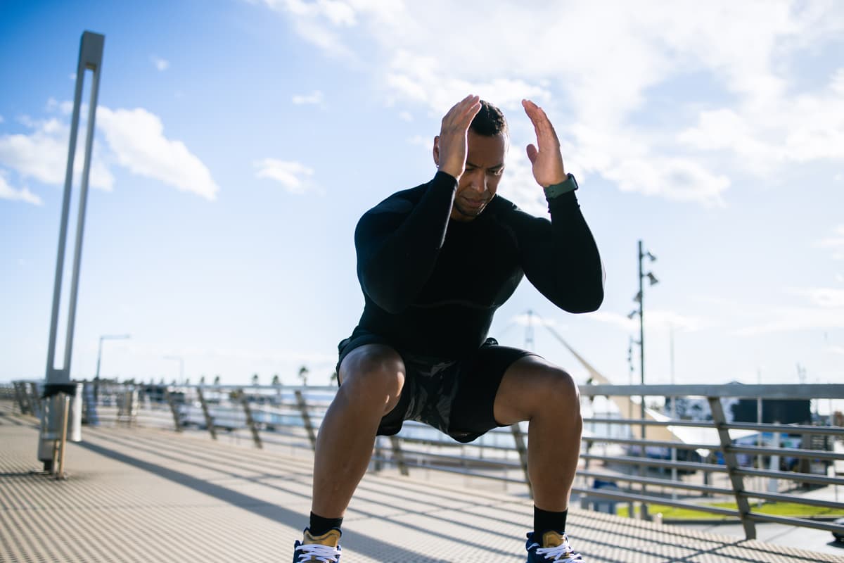 Man doing squats outdoors.