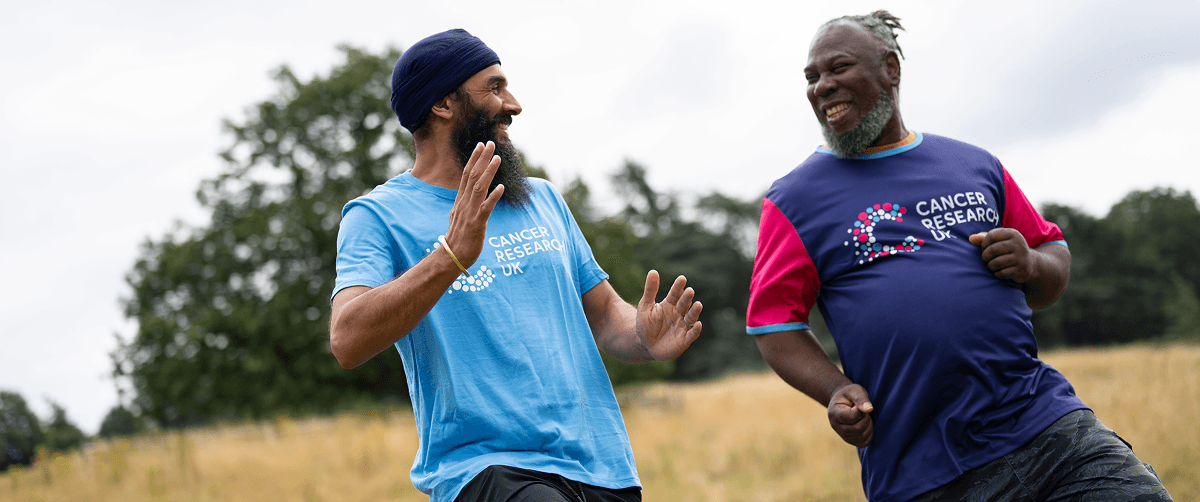 A photo of two men wearing Cancer Research UK t-shirts training outdoors.