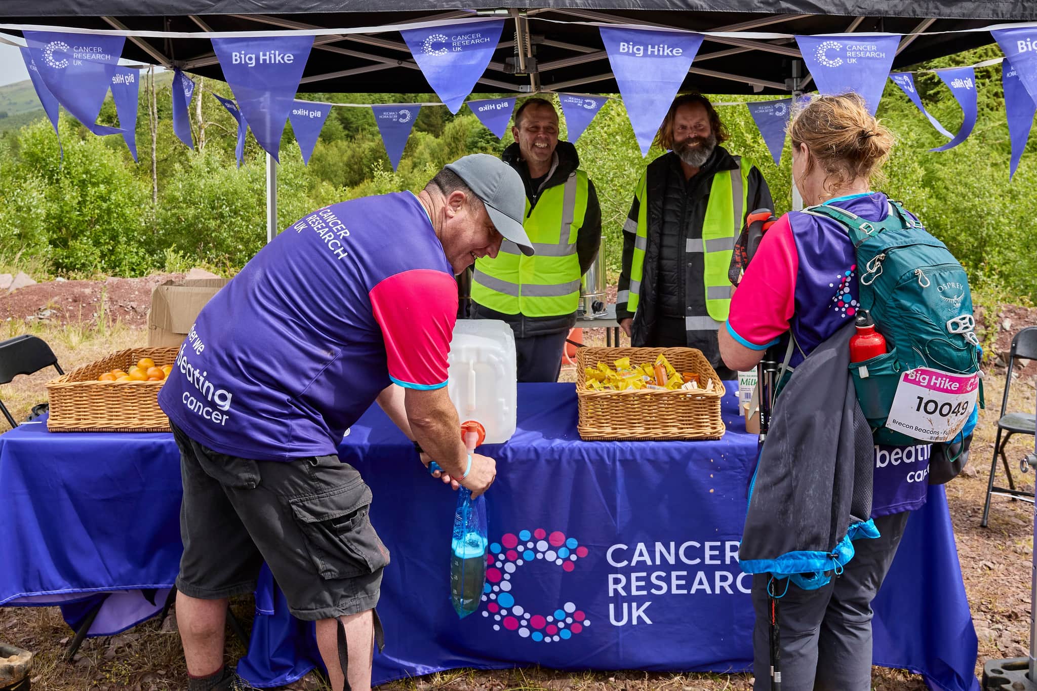 Imagine of volunteers around a Cancer Research UK branded marquee at a Big Hike event.