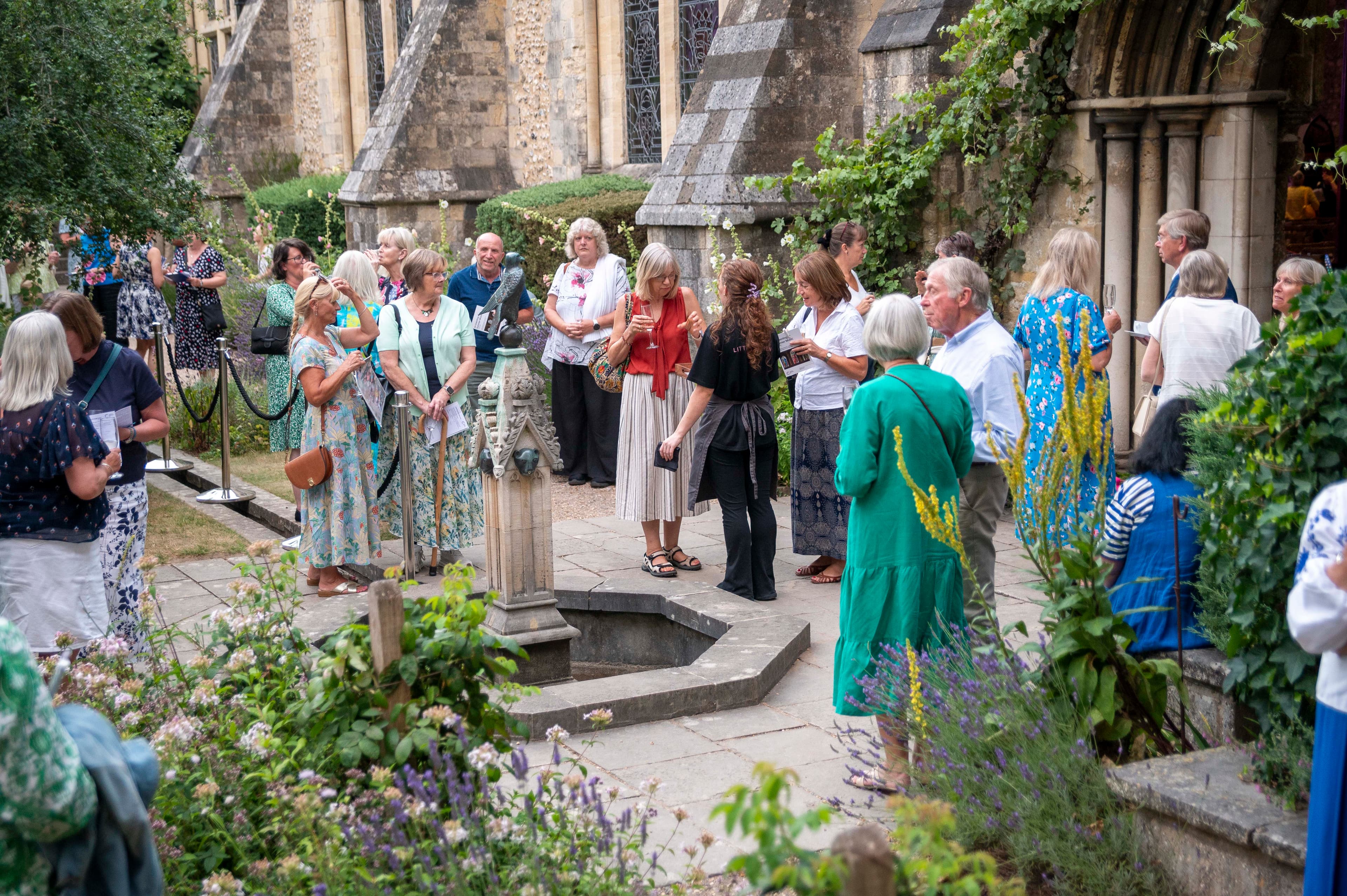 A group of supporters at a Legacy Summer event chatting in a garden.
