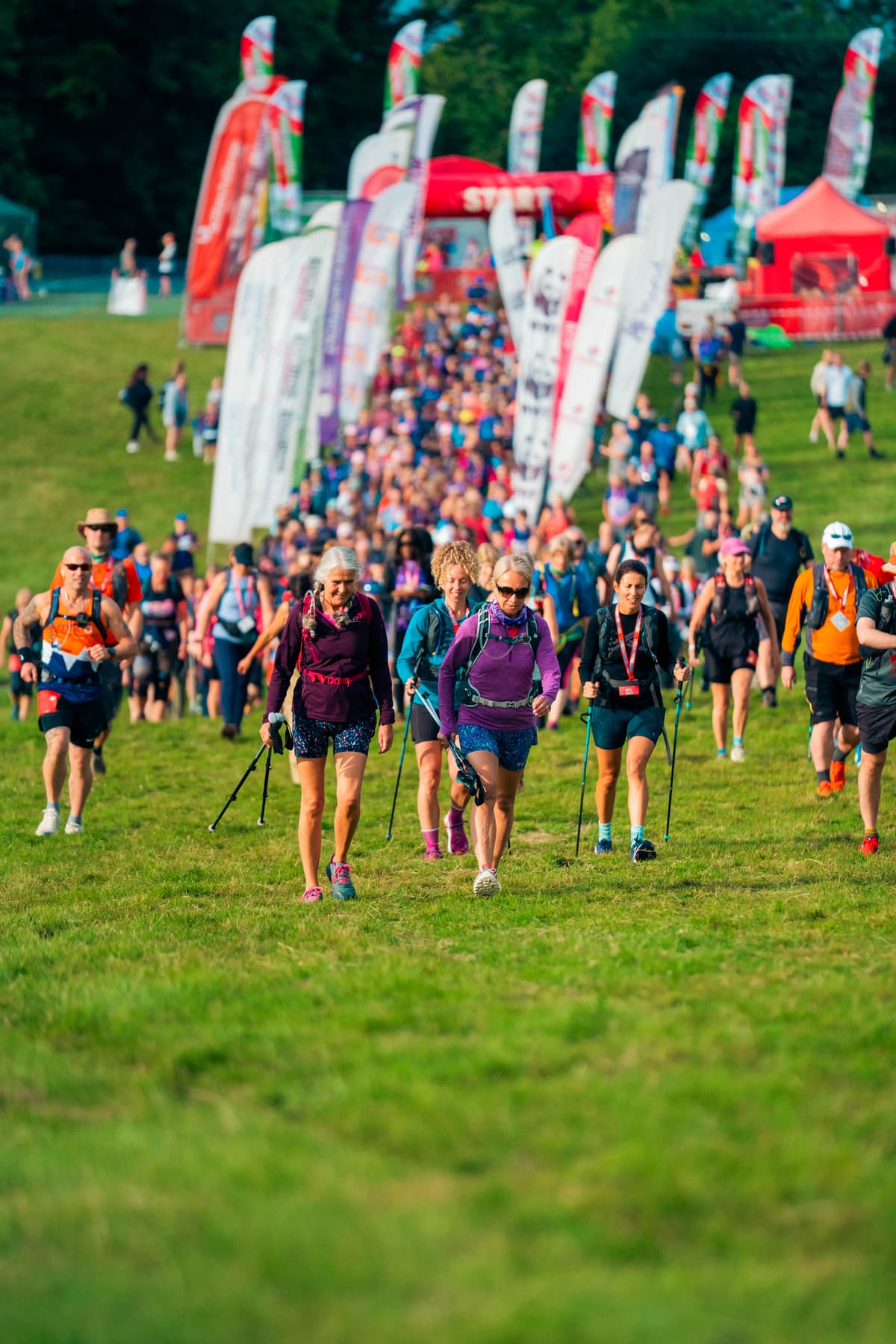 Trekkers taking part in the Peak District Challenge, with banners in the background.