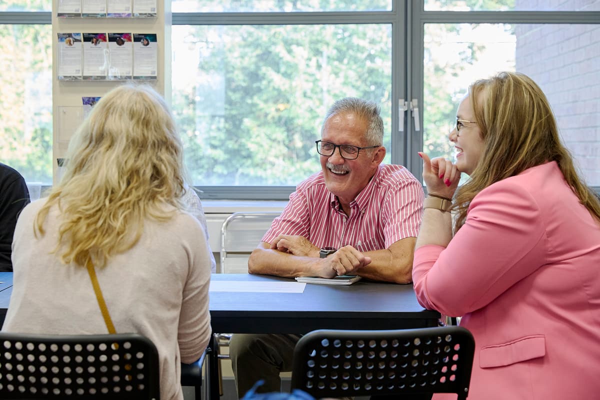 Image of people sitting around a table talking.