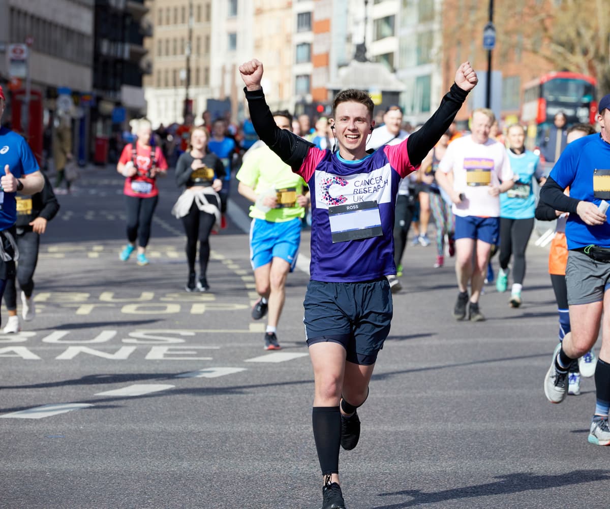 Runner with arms up at race event.