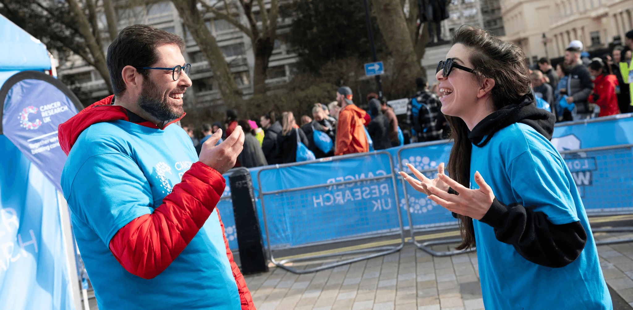 Event volunteer cheering on and high fiving event participants.