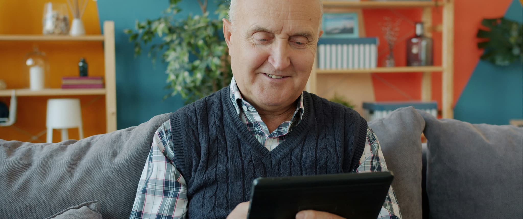 Man smiling at tablet.