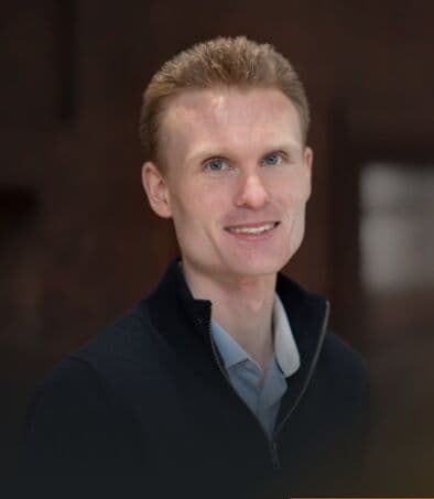 A smartly dressed businessman smiling.