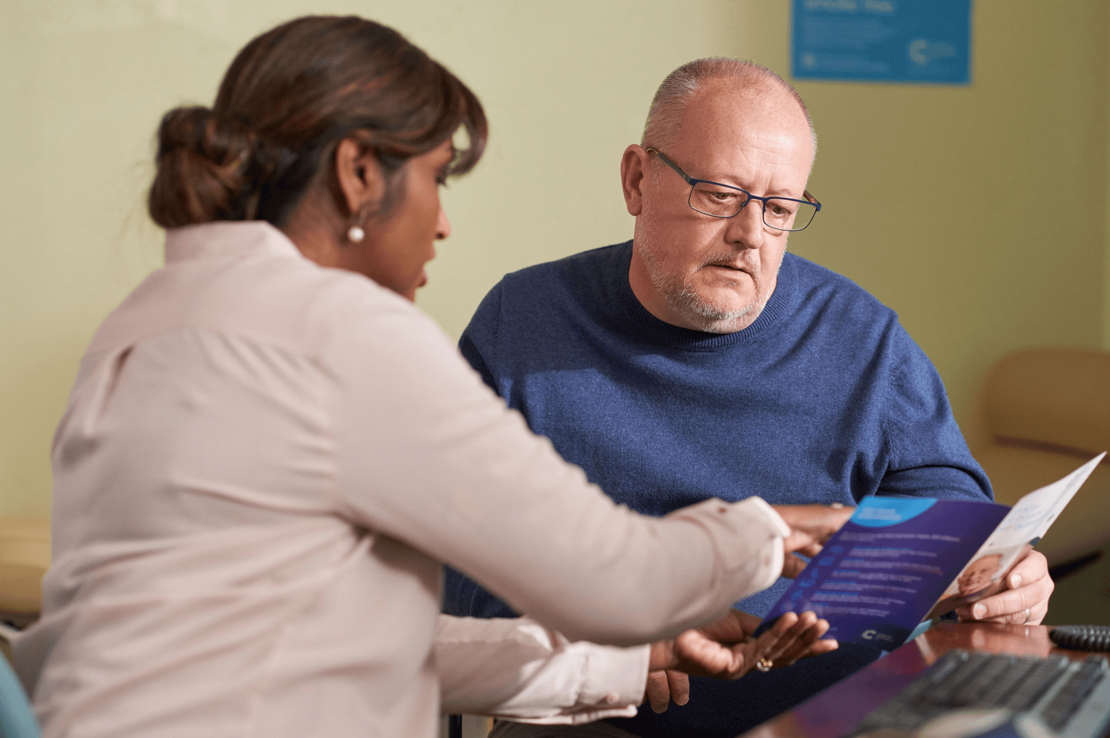 GP explains the information included in a leaflet to man with cancer diagnosis.