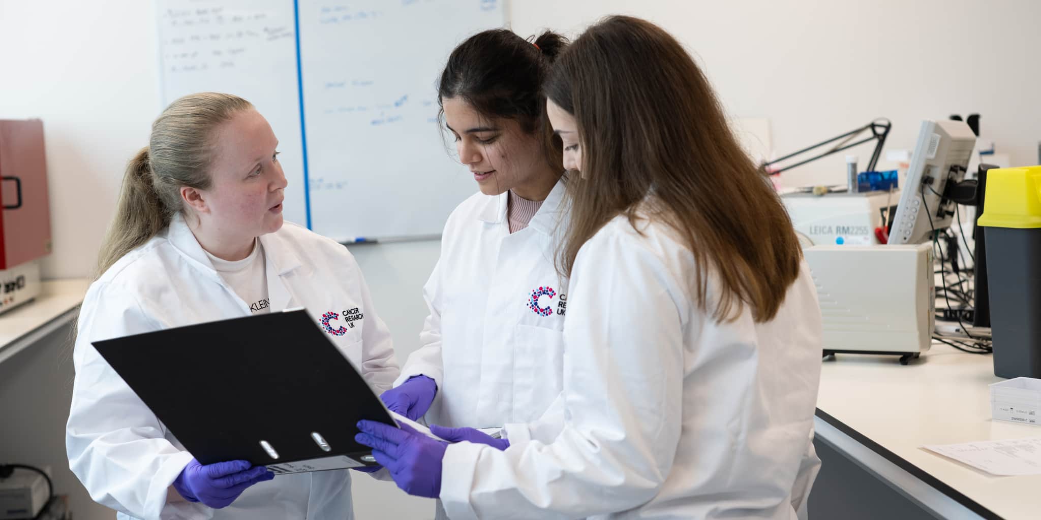 Three researchers looking at a laptop.