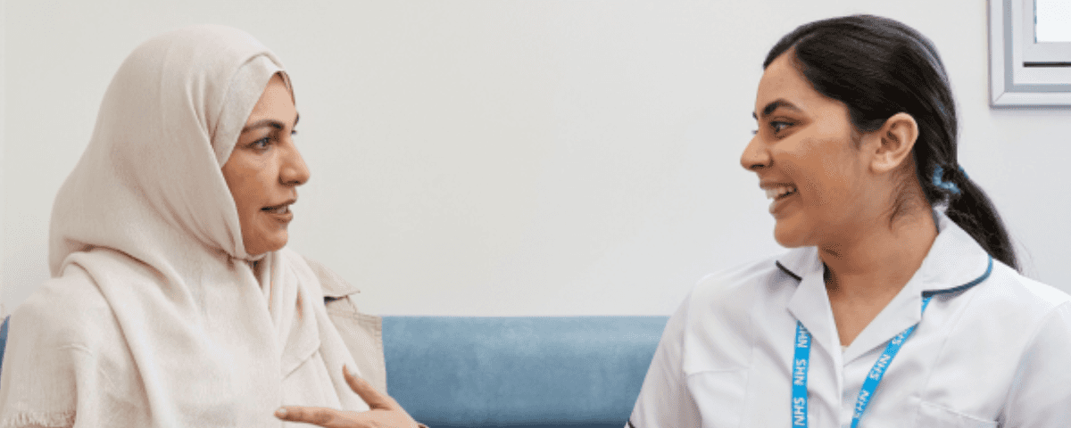 A nurse and patient sat together laughing.