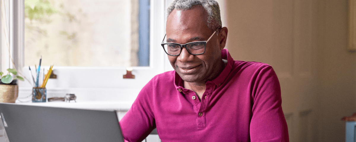 A photo of a man looking at his laptop.