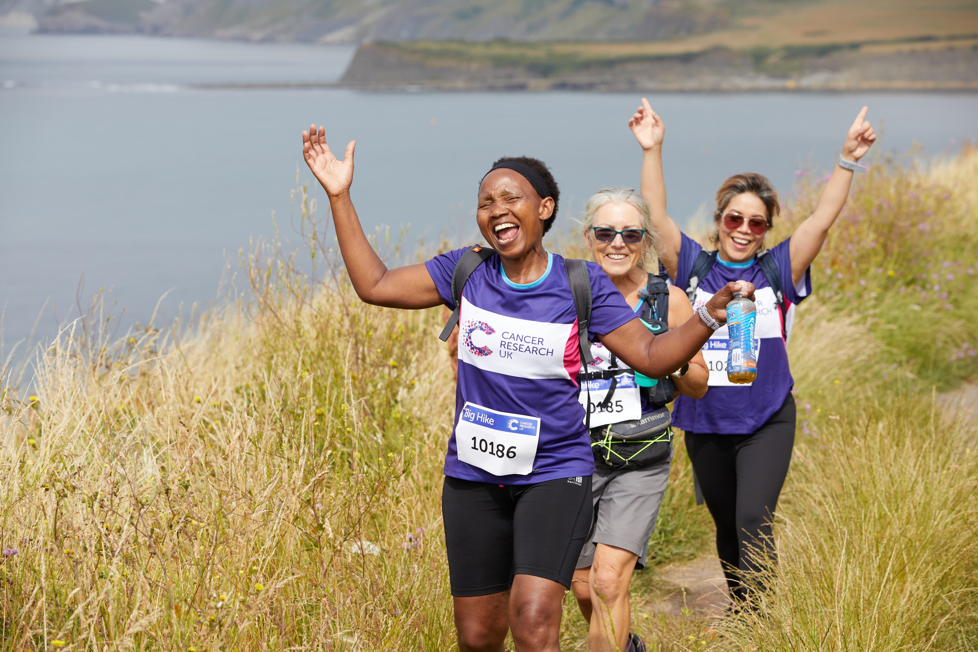 Three hikers walking along the coastline.