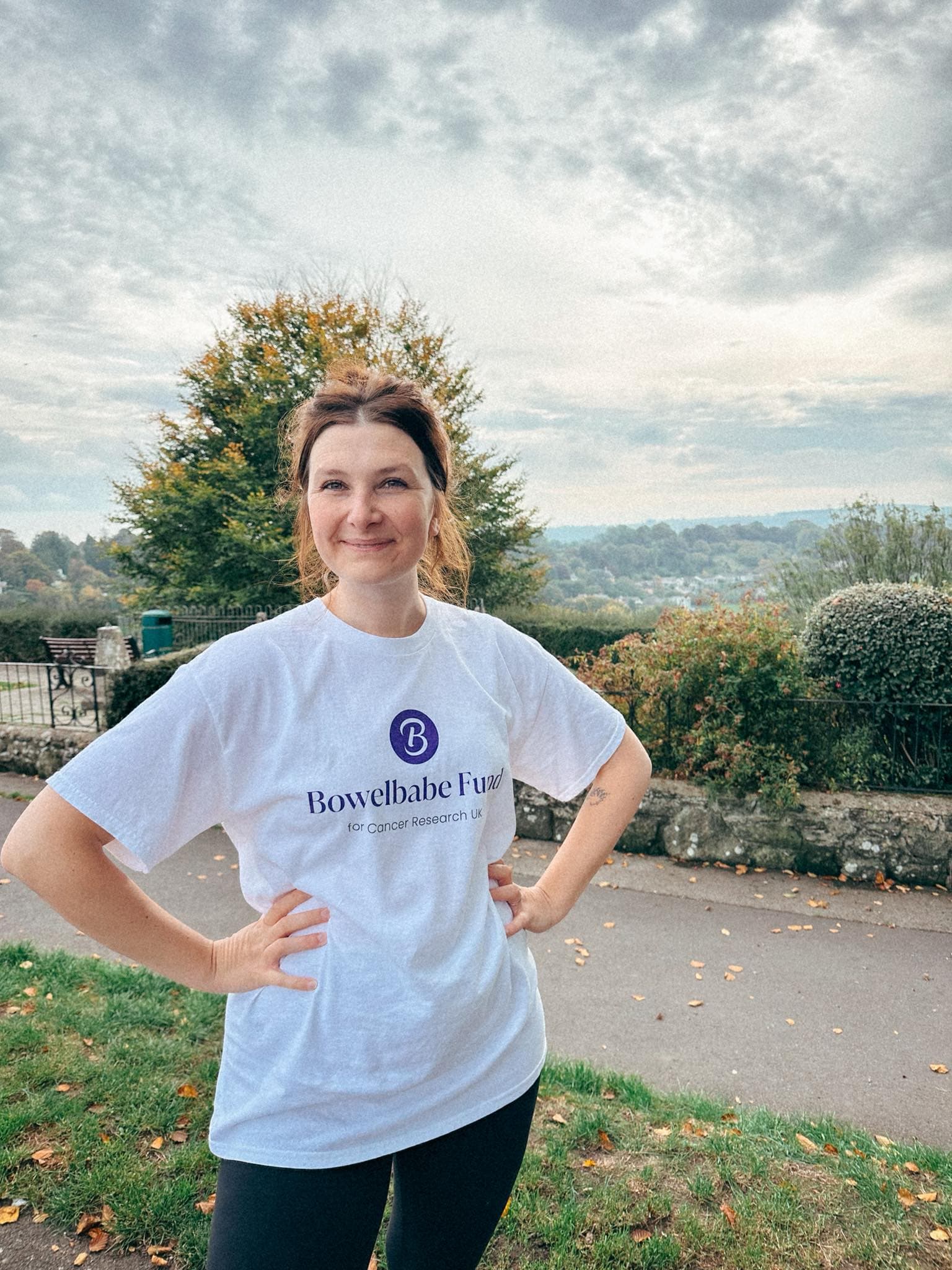 Picture of a women wearing a Bowelbabe Fund t-shirt with her hands on her hips.