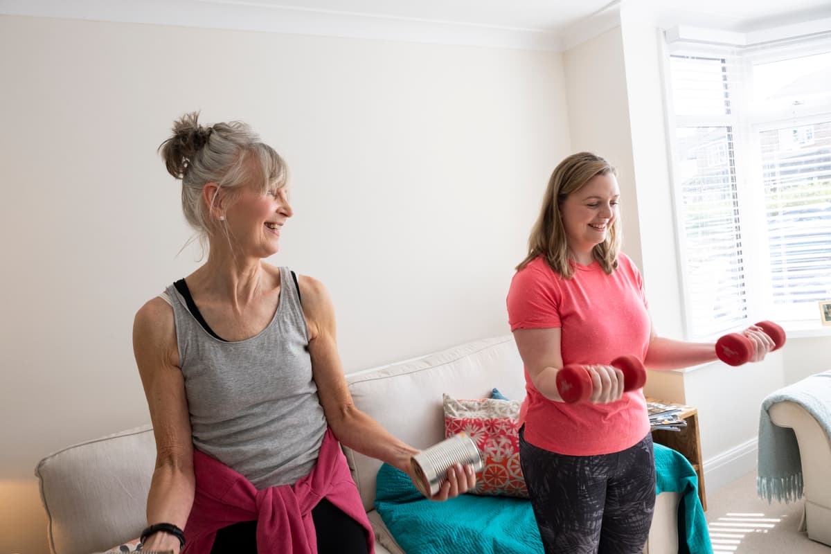 A photo of two women doing a workout at home.