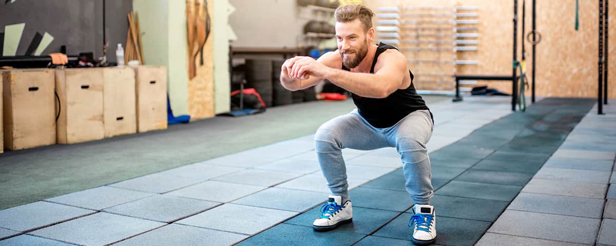 Man doing a squat in a gym.