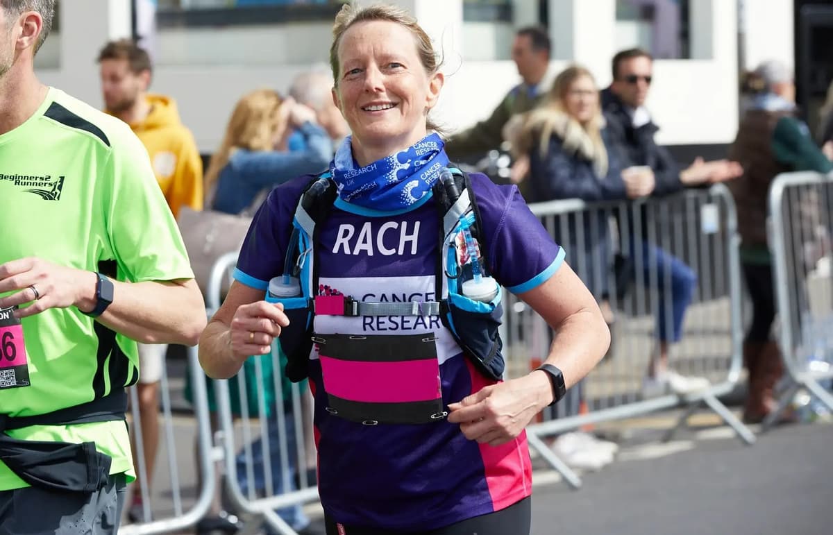 A Cancer Research UK Brighton Marathon runner, smiling.