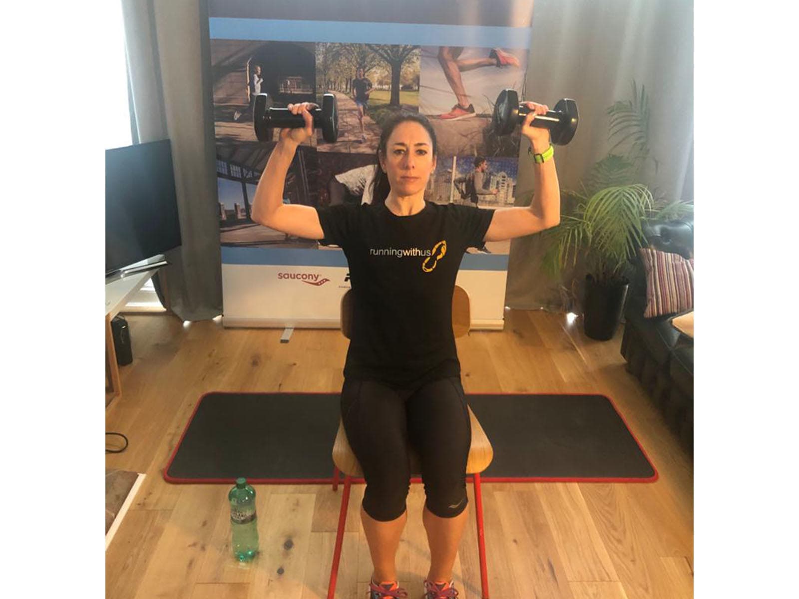 A person executing a dumbbell shoulder press exercise on a chair.