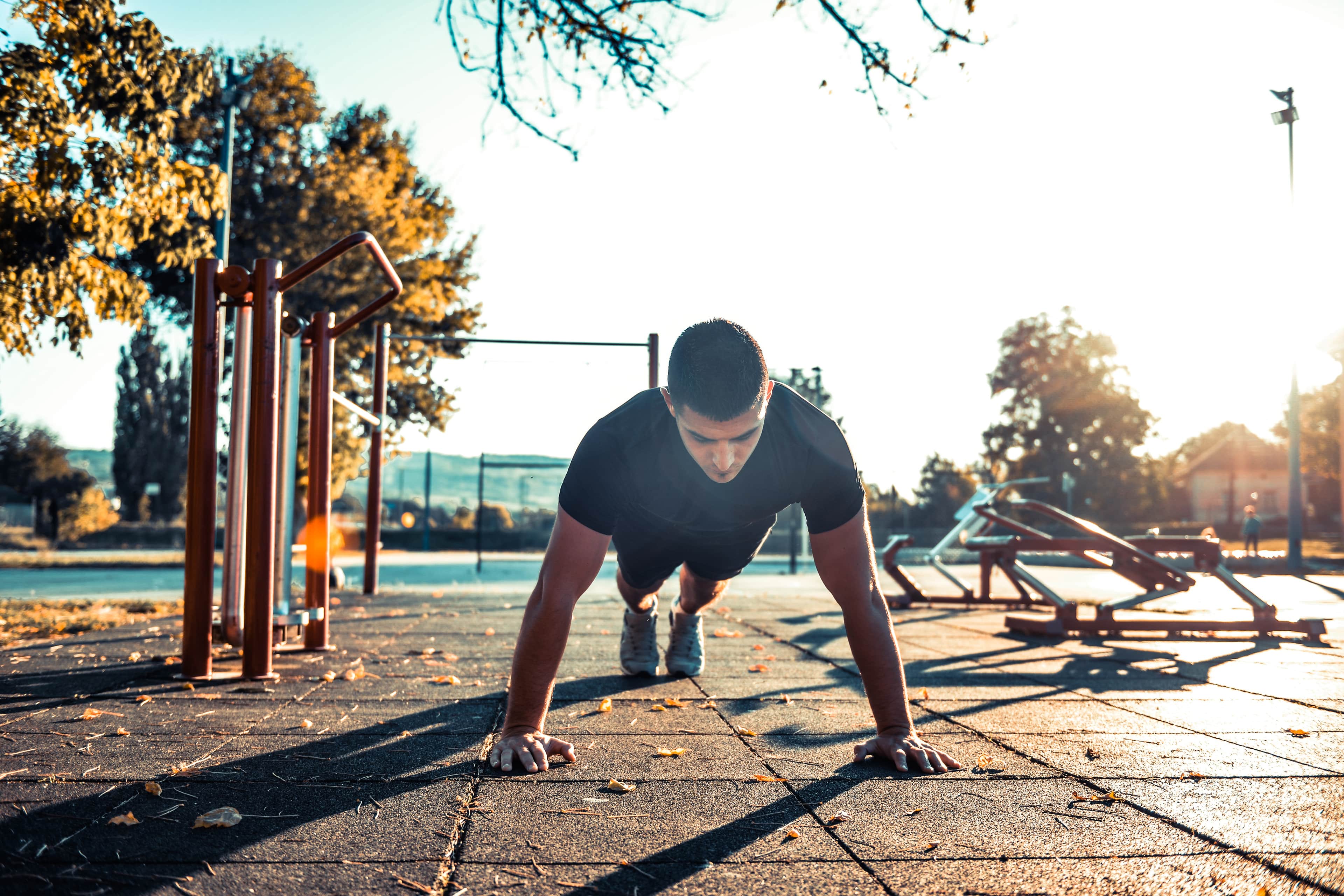 Low-shot of a man doing a push-up outdoors.