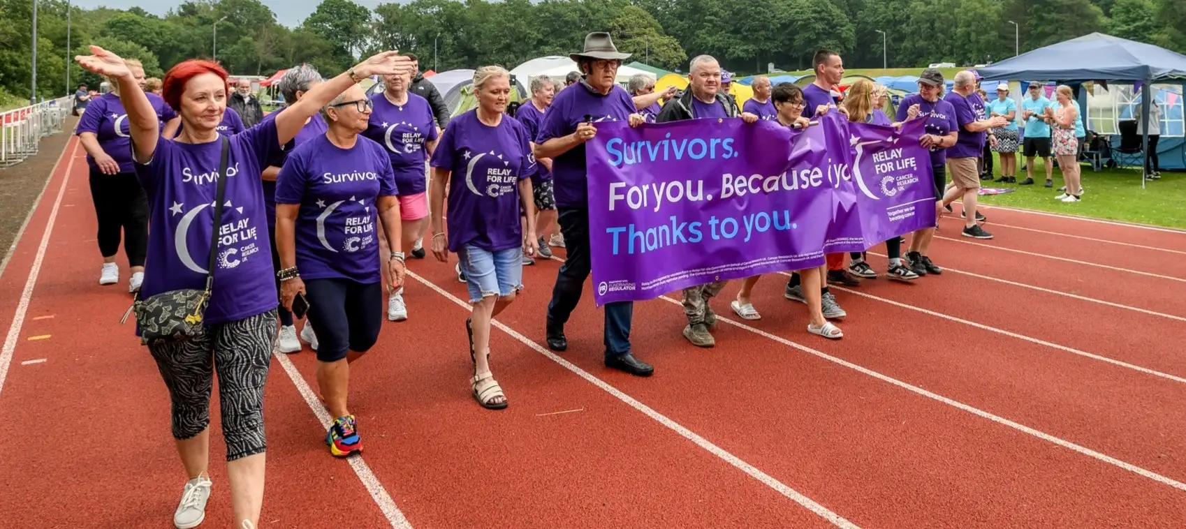 relay in action with people walking around a running track.