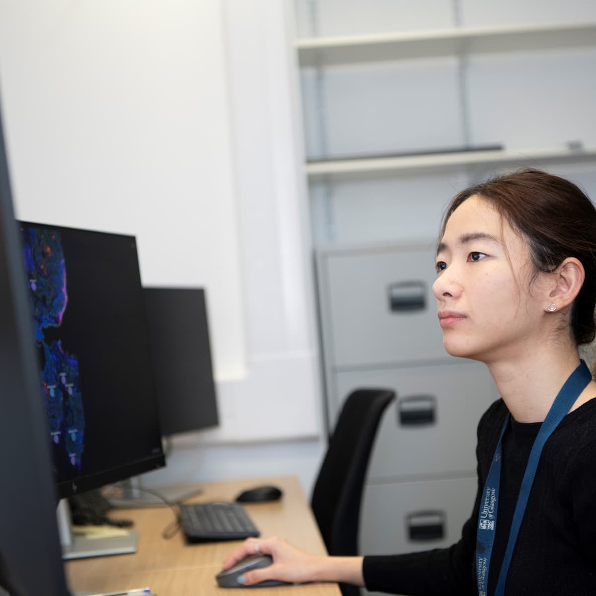 Researcher looking at a monitor at a computer desk.