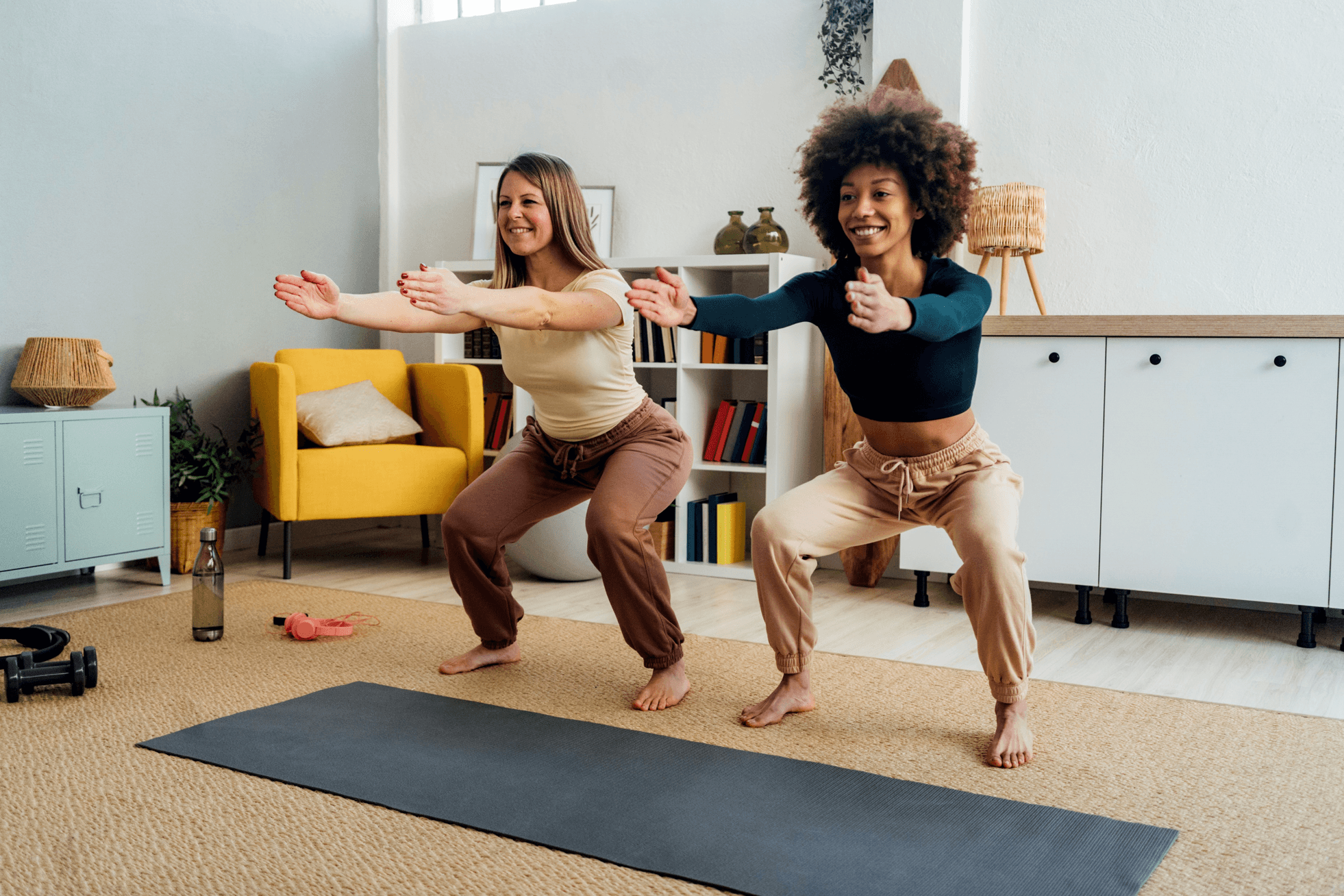 A picture of two women smiling whilst squatting.