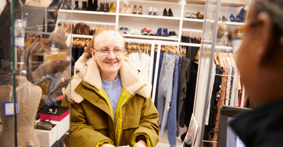 Shop volunteer working and smiling.