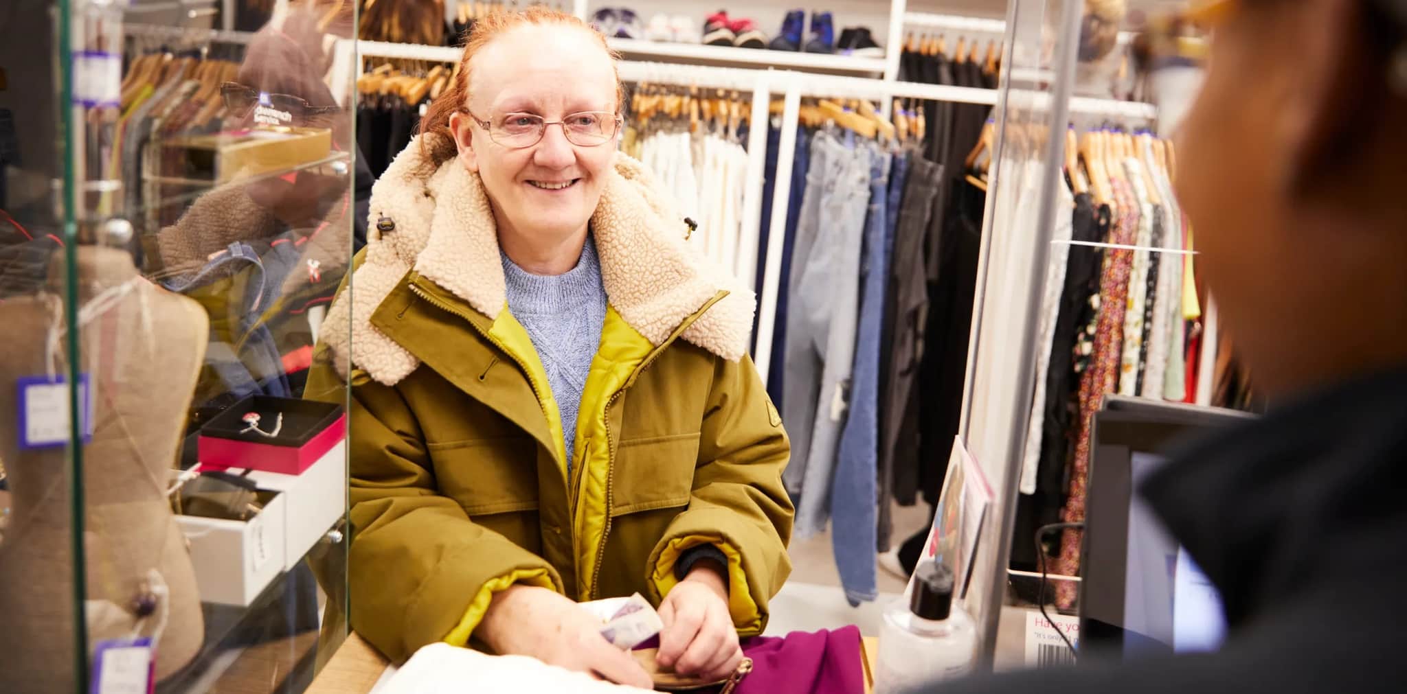 Shop volunteer working and smiling.