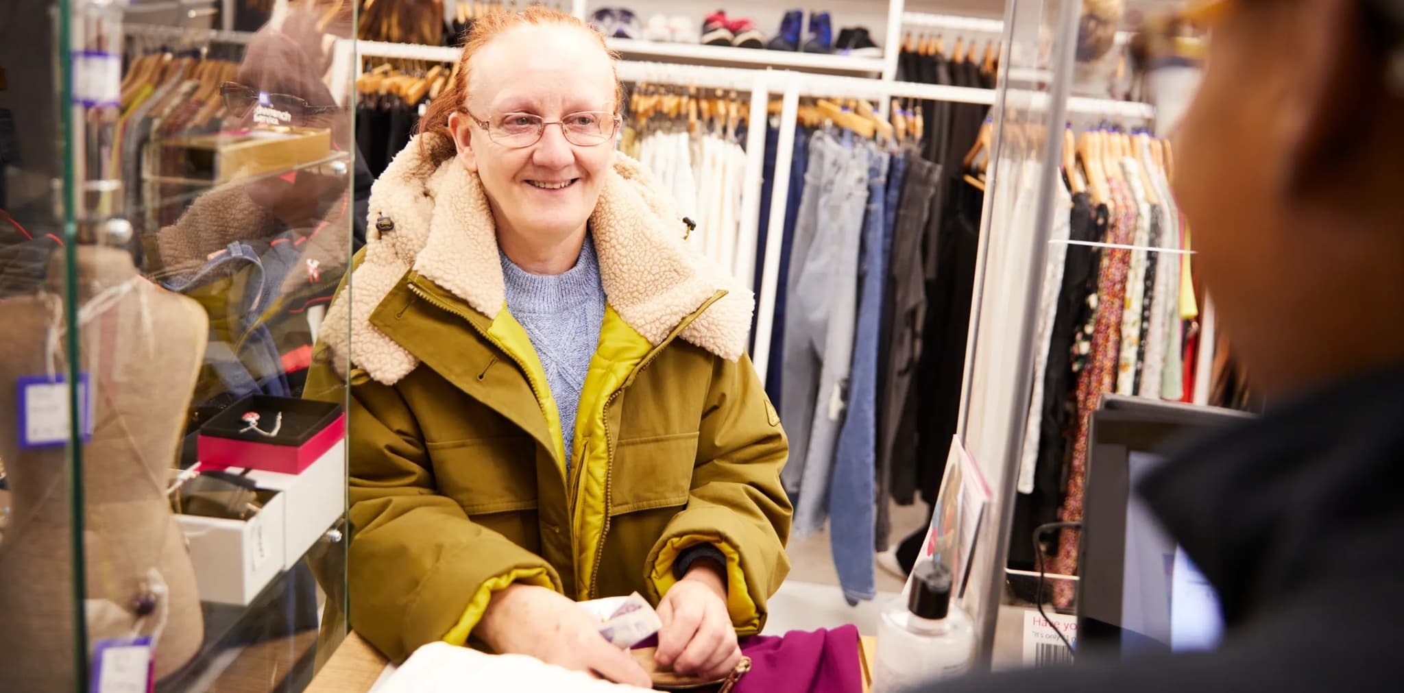 Shop volunteer working and smiling.