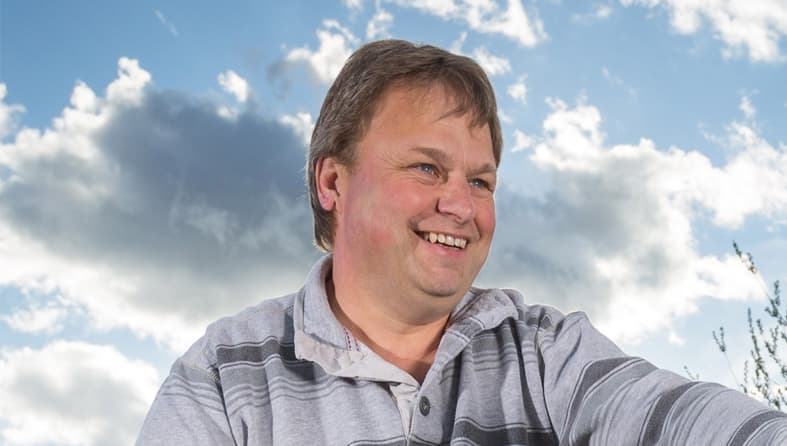 Laine, a lymphoma patient, smiling on a bright, cloudy day.