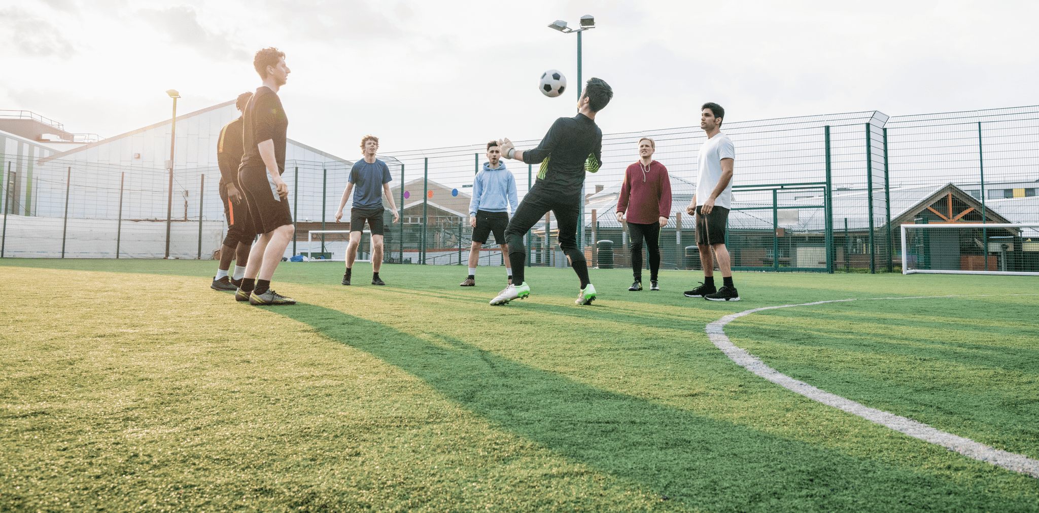 Group doing keepy-uppies outside on a pitch.