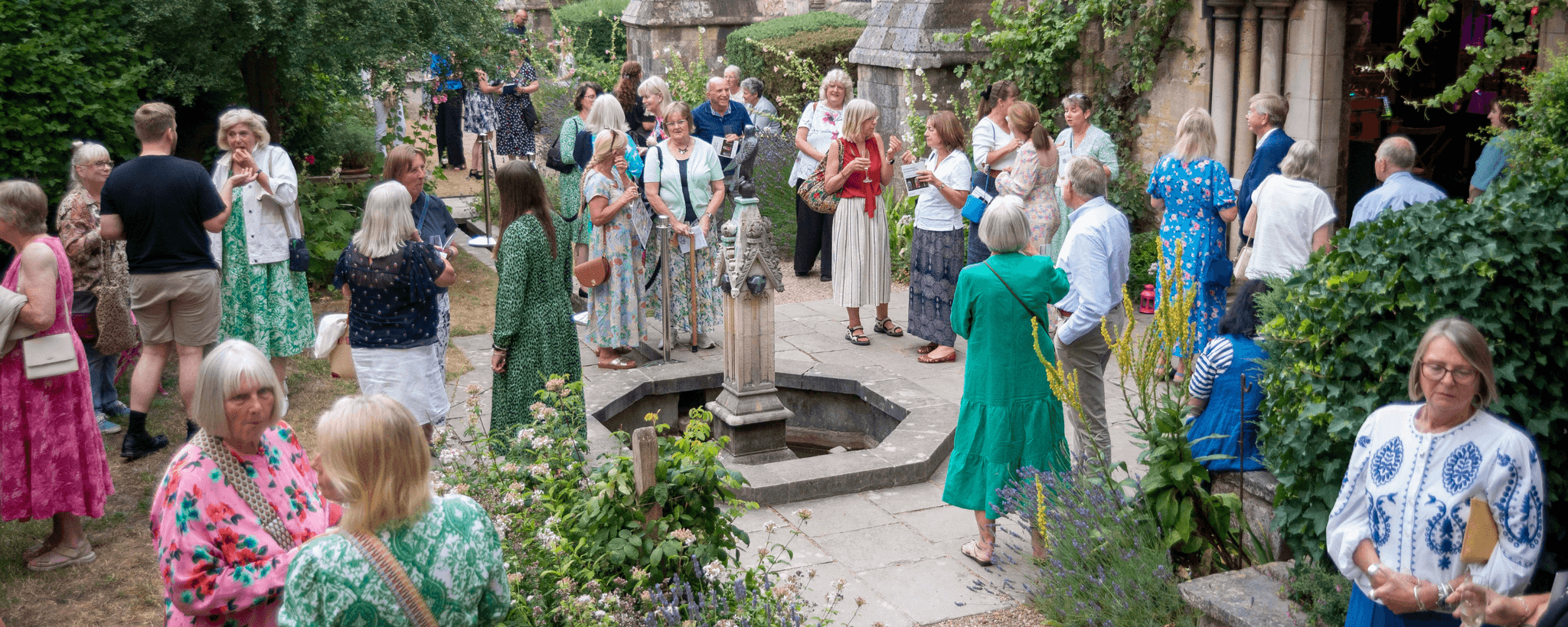 A large group of people chatting in a courtyard at a Legacy Summer of Music event.