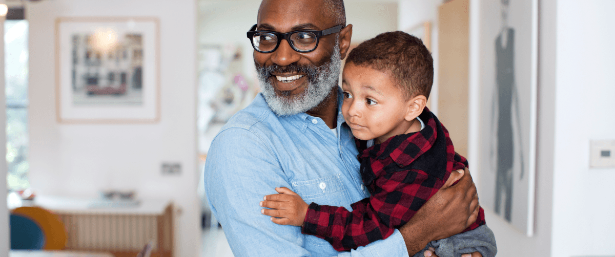 Grandson in grandfathers arms.
