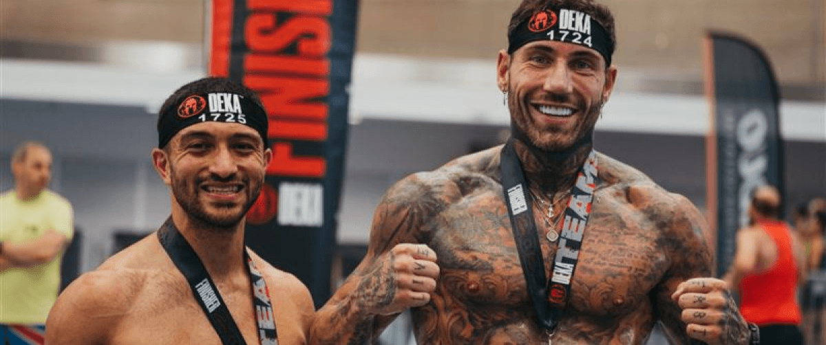 Two men have completed DEKA- they are smiling with medals.