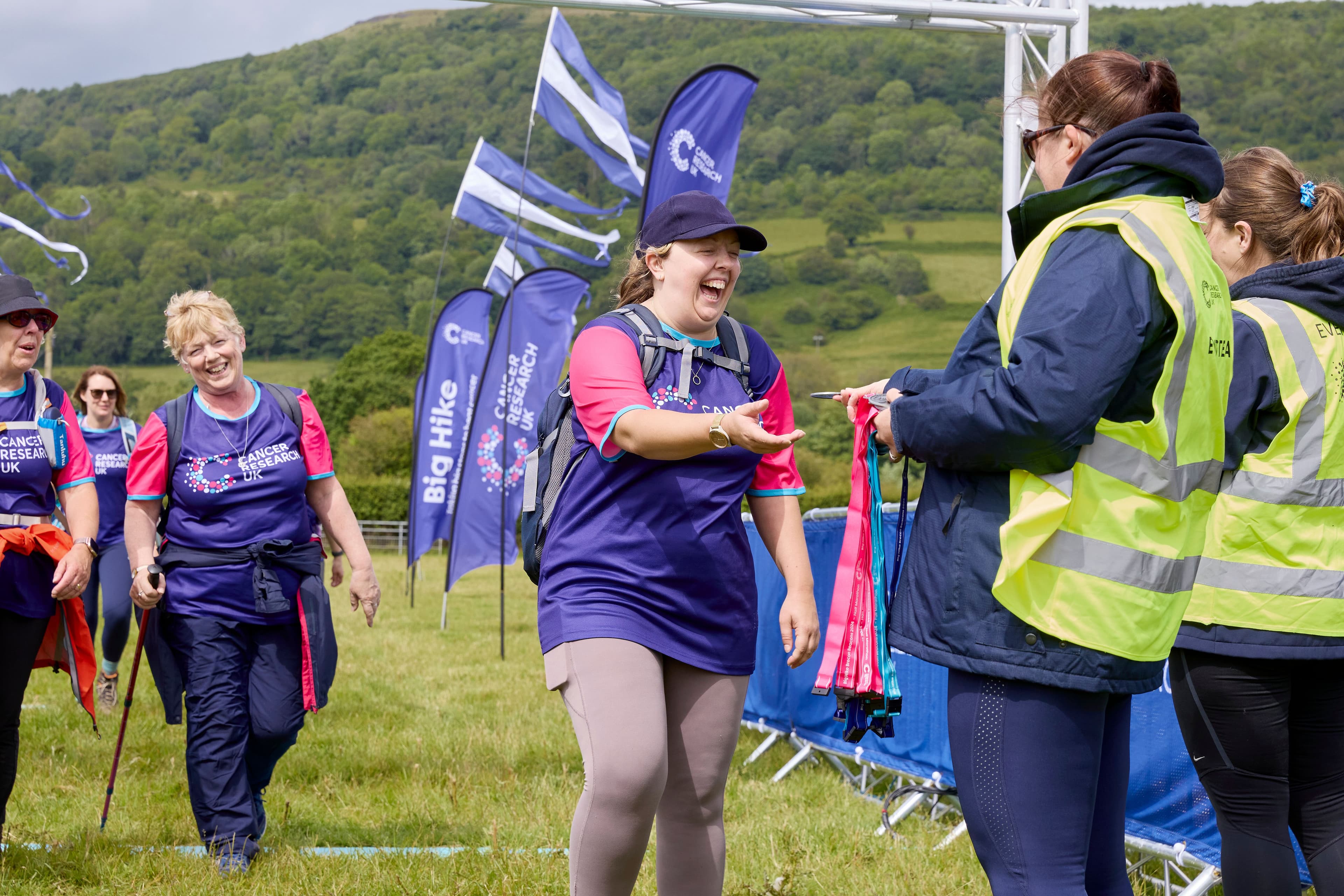 A Big Hike volunteer giving a medal to a participant at the end of their hike.