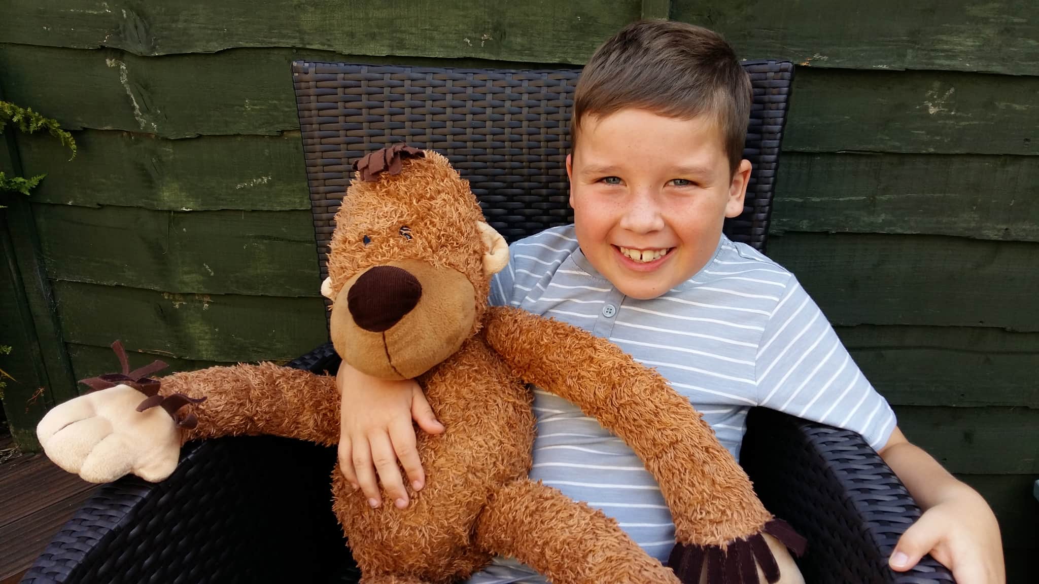 Rhys - a brain and nerve cancer patient, smiling and holding a teddy.